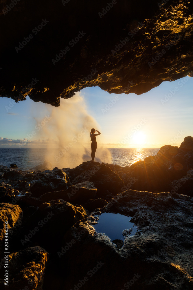 Fototapeta premium Woman watching the sunset at Le Souffleur in Saint Leu, Reunion Island