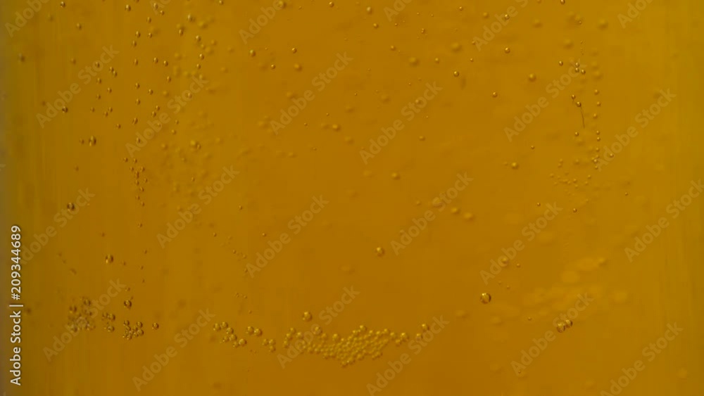 Glass full of beer slow moving bubbles. Yellow drink background Glass full of beer slow moving bubbles. Yellow drink background