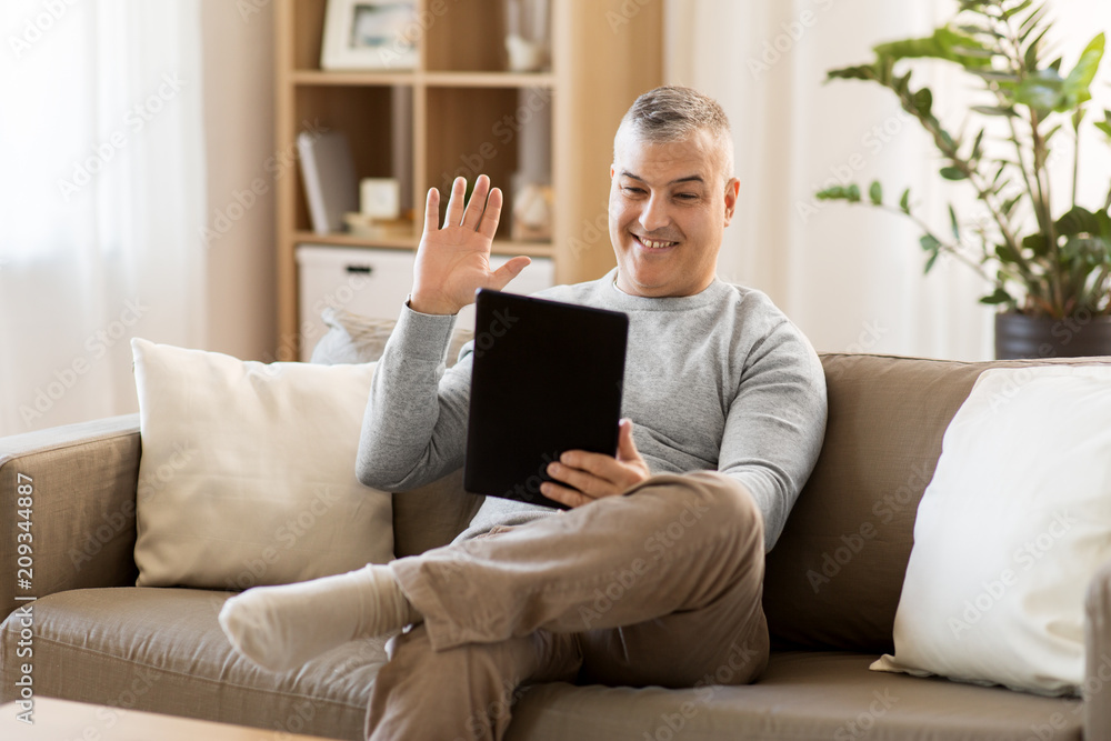 technology, people and communication concept - happy man with tablet pc computer having video chat at home technology, people and communication concept - happy man with tablet pc computer having video chat at home