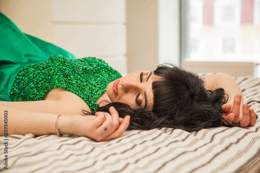 Naklejka premium elegant girl in luxury suites. Brown-haired woman in an emerald expensive dress. The life of a rich girl.