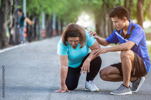 Fotografia Asian man make encouragement to fat woman who sitting on ground