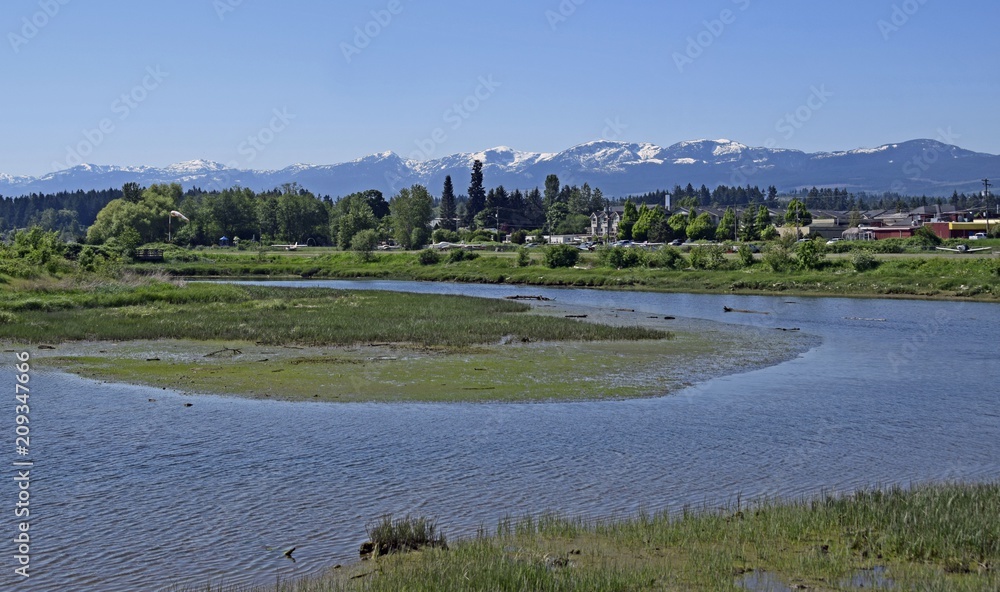 view across the nature preservation project towards the Air Park, Strathcona Park Mountain Range in the background, Courtenay Vancouver Island British Columbia Canada