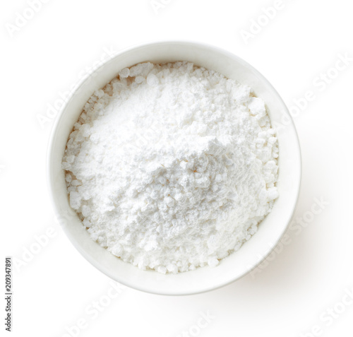 Bowl of powder sugar on white background, from above