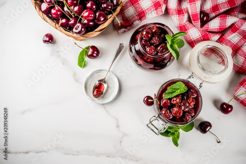 Fototapeta Naklejka Na Ścianę i Meble -  Homemade preserved cherry and mint jam, with fresh cherries on white marble background copy space top view