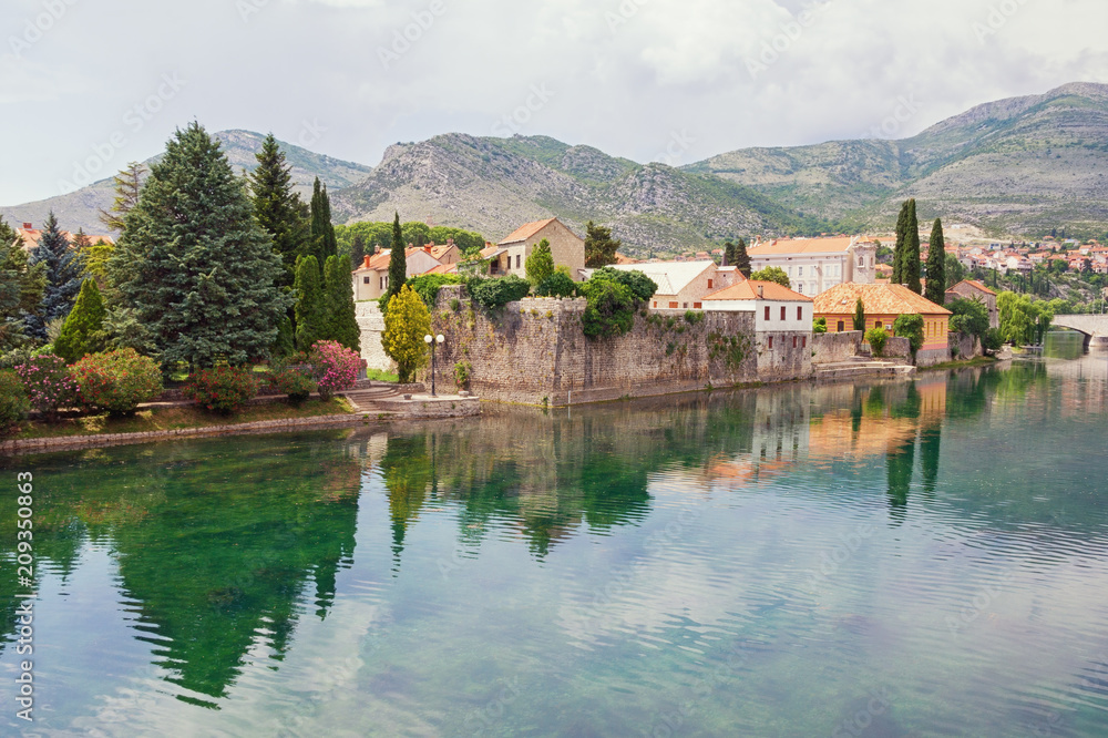 Picturesque landscape with ancient town on river bank. Bosnia and Herzegovina, view of Trebisnjica river and Old Town of Trebinje