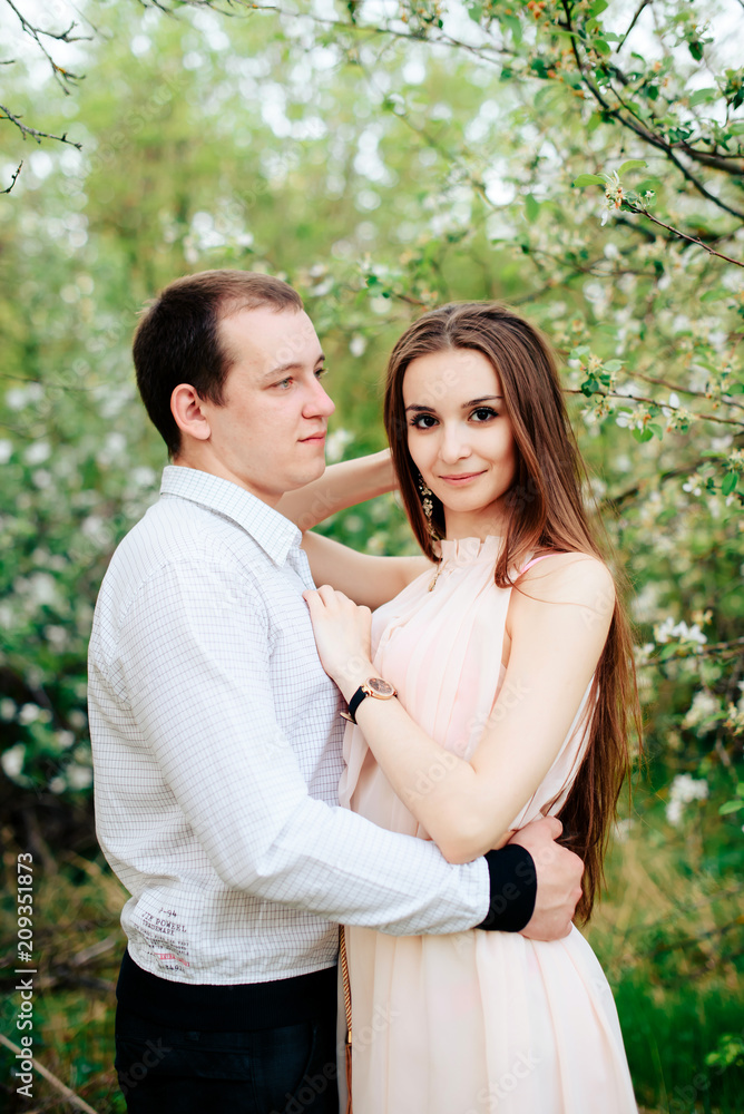 a young couple in love in the spring flowering Park