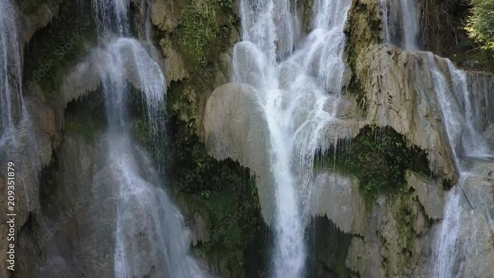 Picturesque Kuang Si waterfall in Loas. Water falling from rocks. Drone shot. Close up. Picturesque Kuang Si waterfall in Loas. Water falling from rocks. Drone shot. Close up.