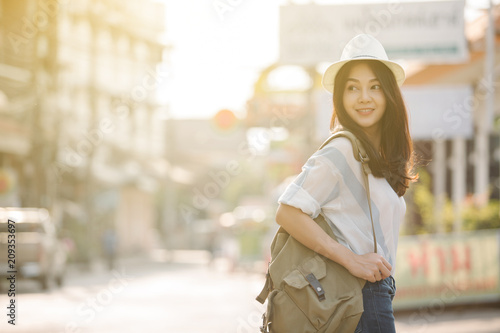 Summer sunny lifestyle fashion portrait of young stylish hipster Asia woman walking on the street, wearing cute trendy outfit
