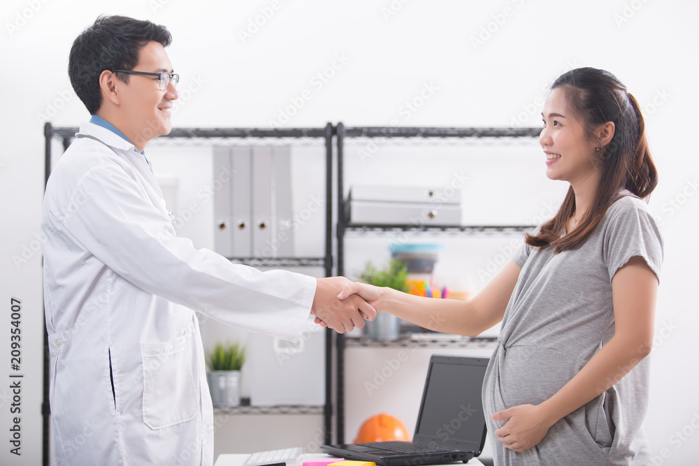 Obraz premium Pregnant Woman Shaking Hands With Doctor