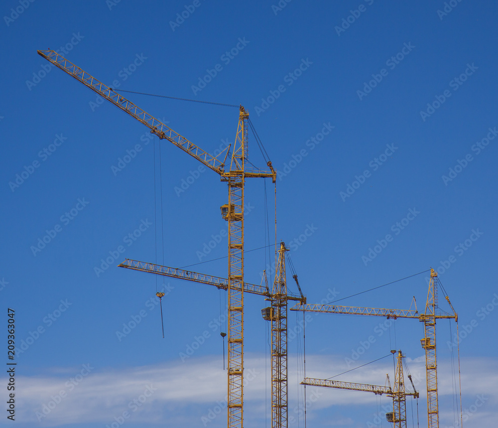 construction cranes against the blue sky