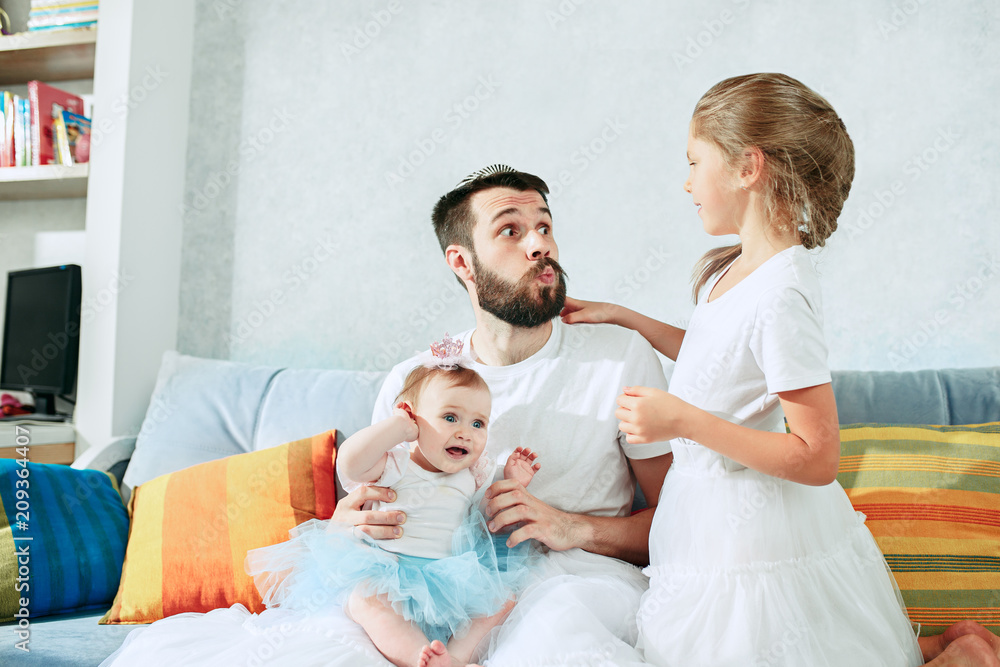 The happy father and his baby daughters at home The happy father and his baby daughters at home