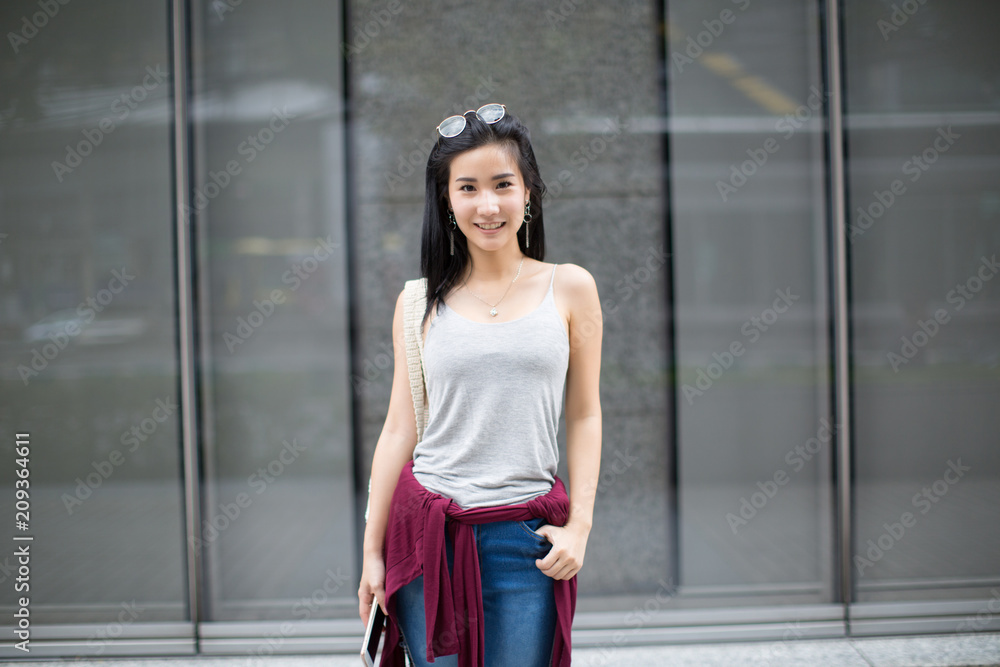 lifestyle fashion portrait of young stylish hipster Asia woman walking on the street, wearing cute trendy outfit