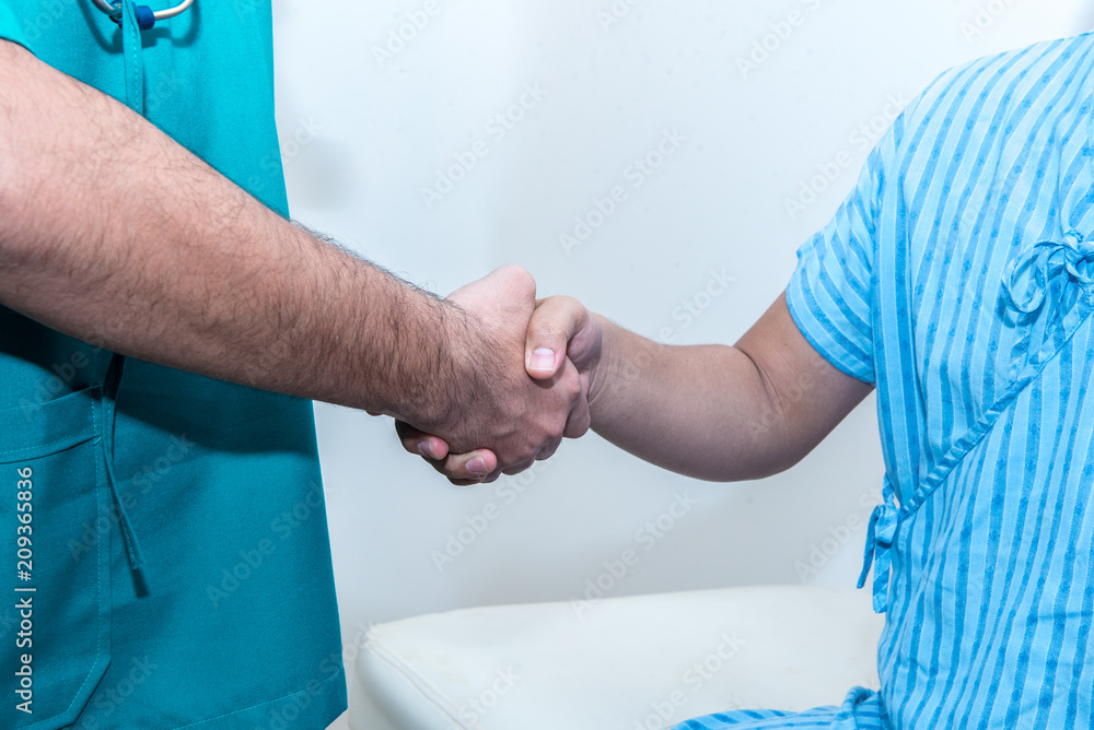 Doctor with stethoscope having conversation and shaking hands with his patient, worry, nervous situation concept. Doctor with stethoscope having conversation and shaking hands with his patient, worry, nervous situation concept.