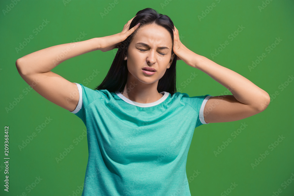 Woman having headache. Isolated over green background. Woman having headache. Isolated over green background.