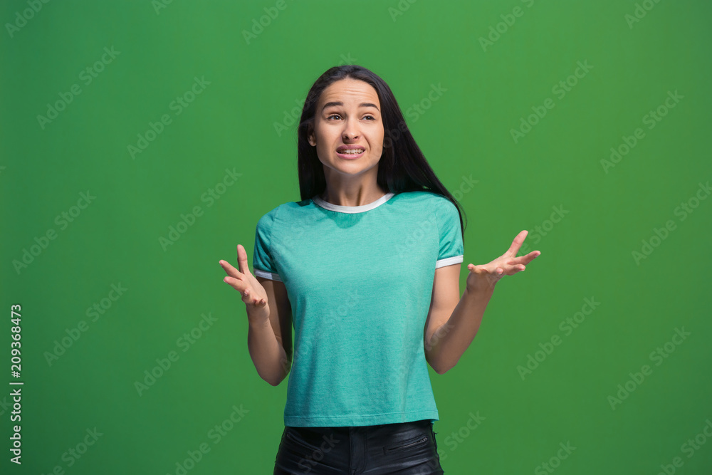 Beautiful female half-length portrait isolated on green studio backgroud. The young emotional surprised woman Beautiful female half-length portrait isolated on green studio backgroud. The young emotional surprised woman