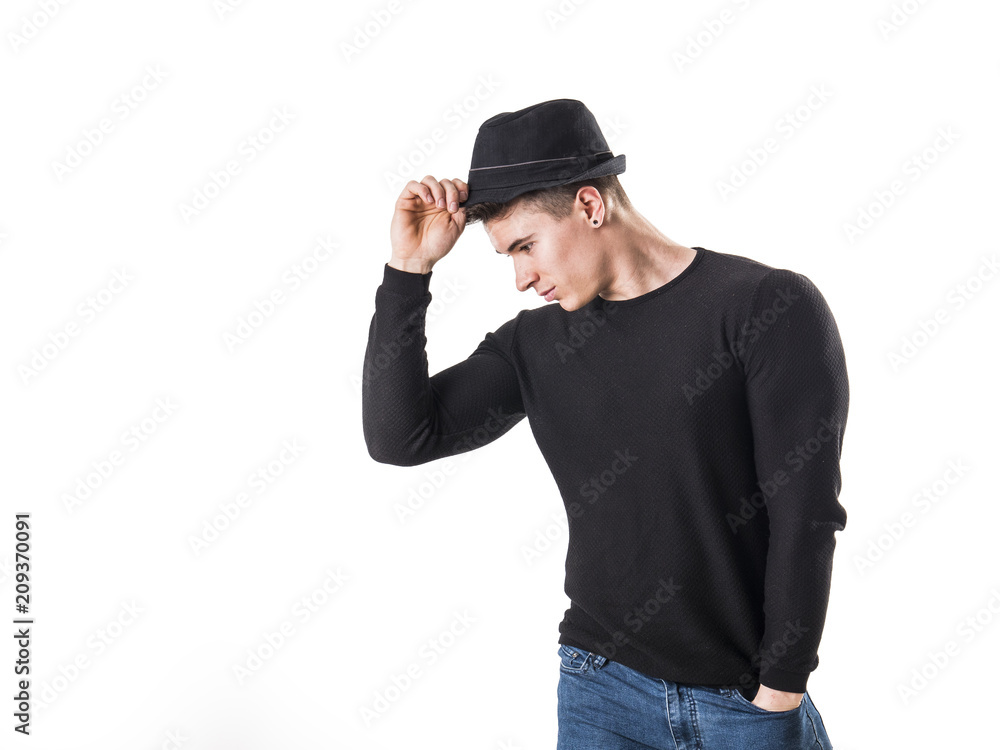 Handsome young muscular man looking down in studio shot, wearing fedora hat, isolated on white background Handsome young muscular man looking down in studio shot, wearing fedora hat, isolated on white background