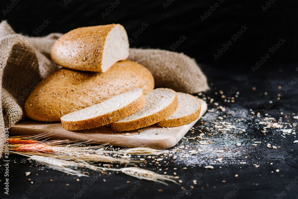 Sweet fresh bread with ingredients on black wooden background