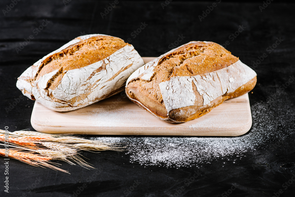 Fresh french bread on black wooden background