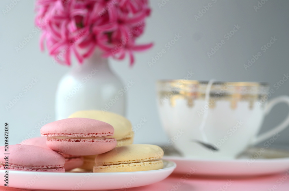 Bright pink hyacinth with French macarons, cup of coffee and gold black stationery. Female and lifestyle business and work from home concept. Spring theme. Bright pink hyacinth with French macarons, cup of coffee and gold black stationery. Female and lifestyle business and work from home concept. Spring theme.