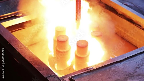 Hot metal ingot being loaded into water. Hardening in a factory