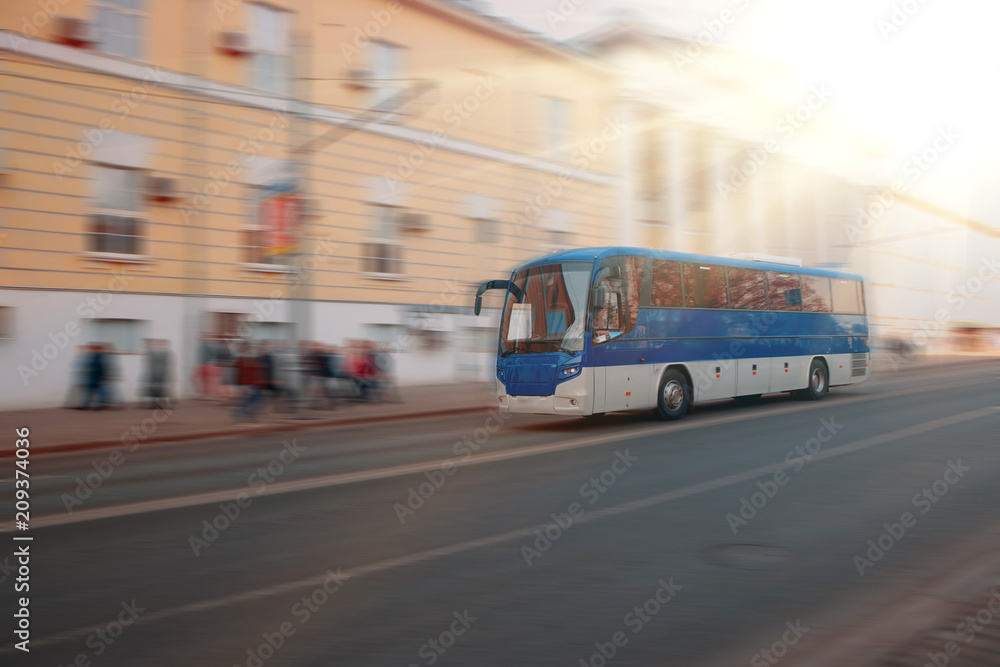 Excursion city bus moves along large city street. Motion blur. Sunny day