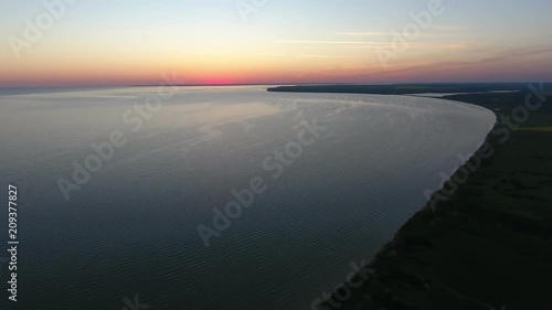 An arty bird`s eye view of the dark and mountaneous Black Sea shore at a golden sunset with a palette of orange, pink, and yellow colors photo