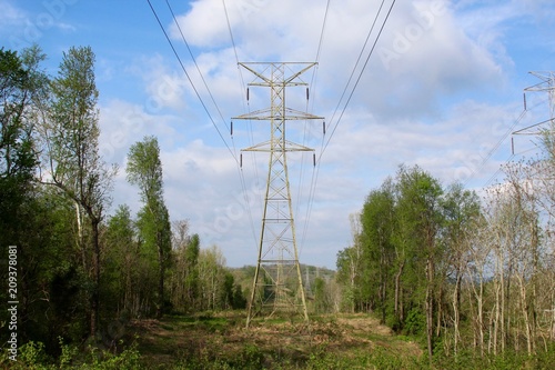 The high voltage power towers in the country landscape.