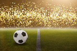 Fußball im Stadion vor hellen goldenen Lichtern
