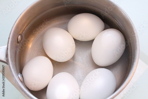 White boiled eggs in a pot of water. Close-up.