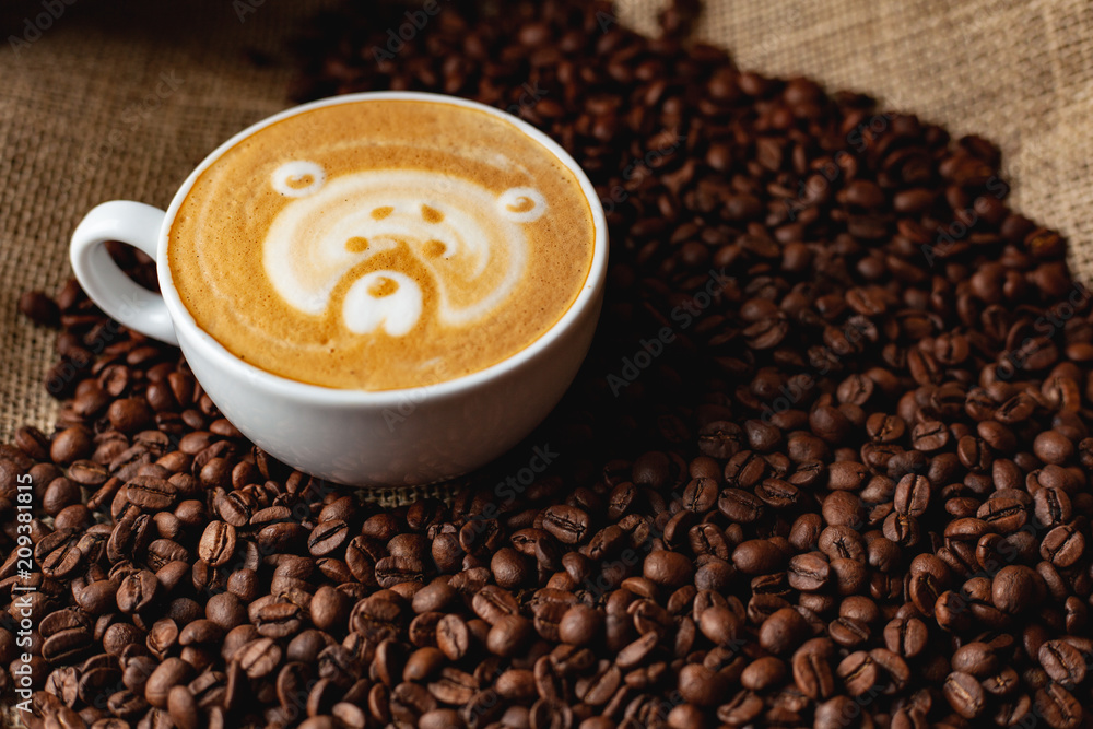 Cappuccino with a pattern on the background of coffee beans Cappuccino with a pattern on the background of coffee beans