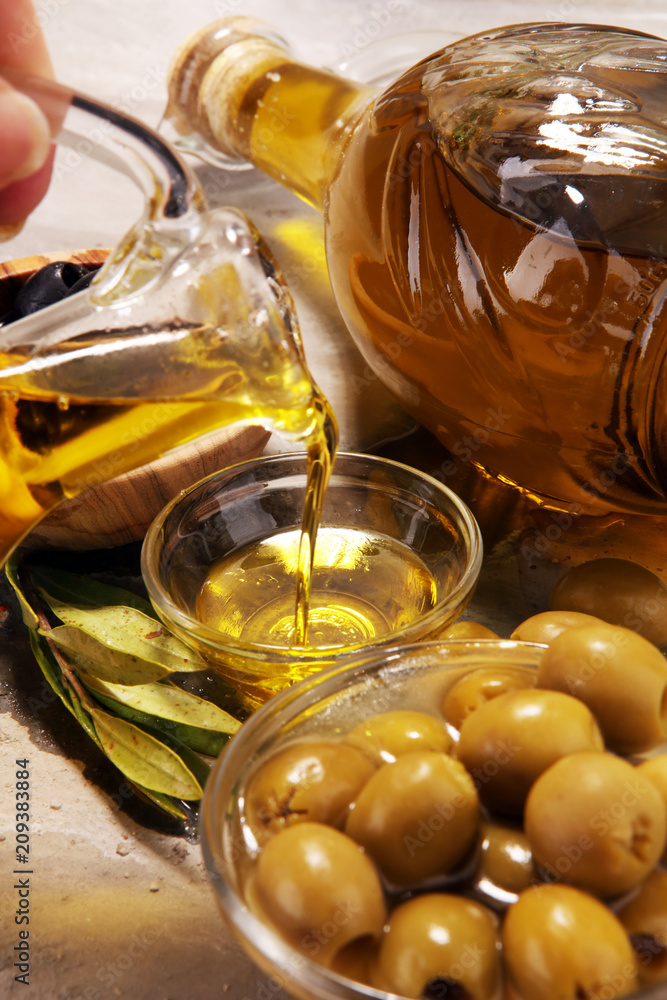 Bottle virgin olive oil and oil in a bowl with some olives Bottle virgin olive oil and oil in a bowl with some olives