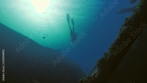 Freediver man cruising inside wreck in deep ocean photo