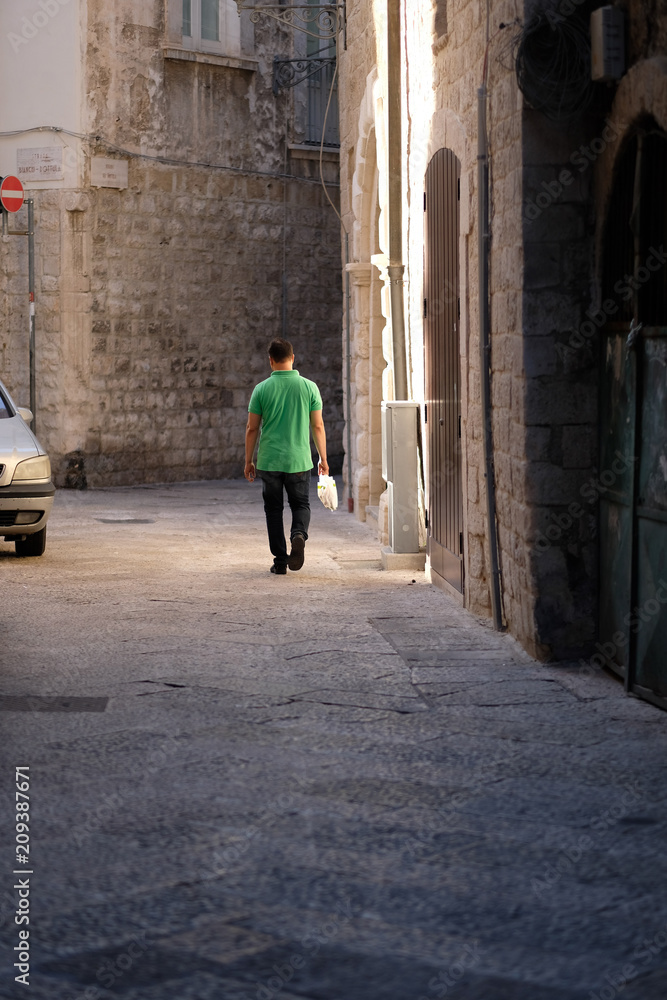 The man is walking along the street of the night city The man is walking along the street of the night city