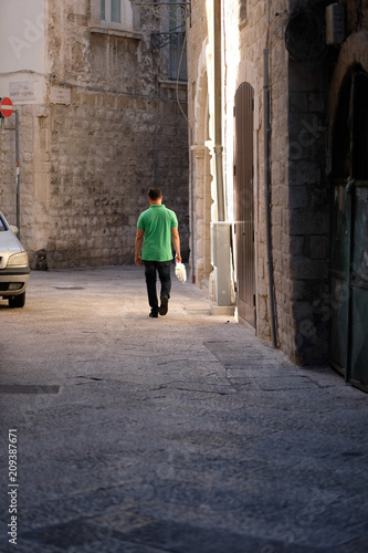 The man is walking along the street of the night city © Anna Jurkovska