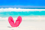Pink flip flops over a tropical sea resort background