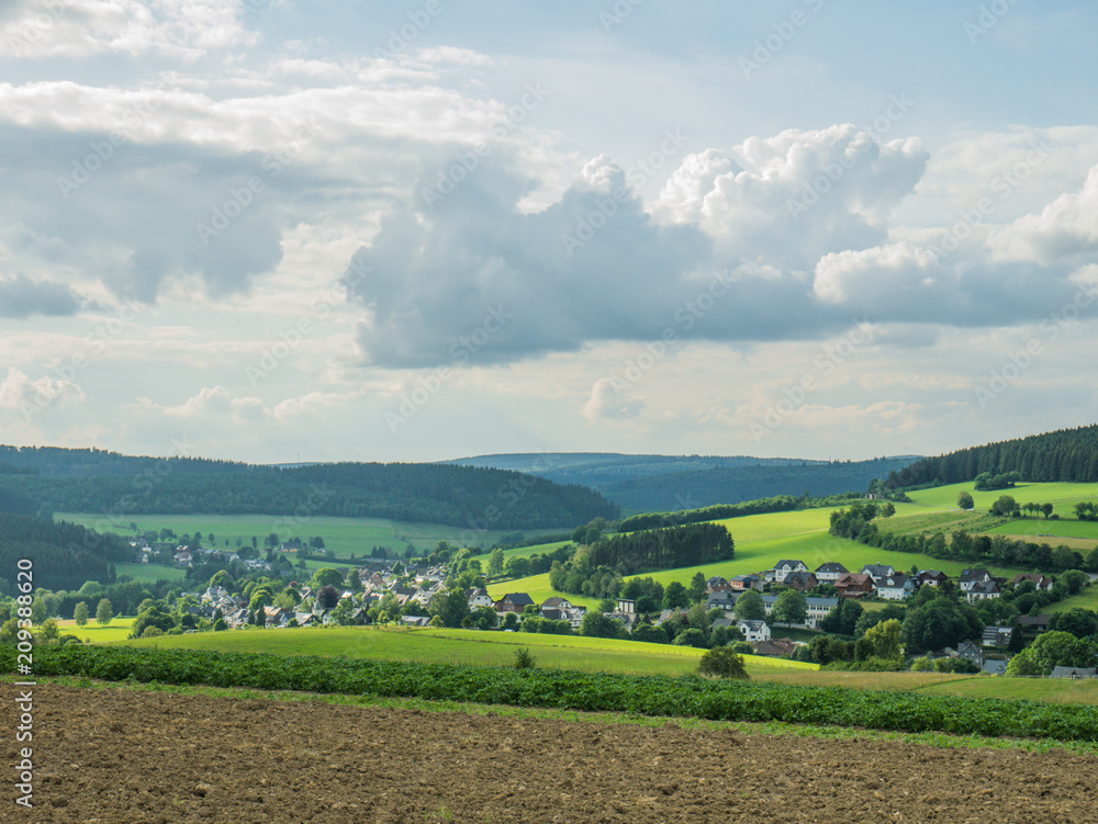Ein Blick auf ein kleines Dorf unter einem bewolktem Himmel Ein Blick auf ein kleines Dorf unter einem bewolktem Himmel
