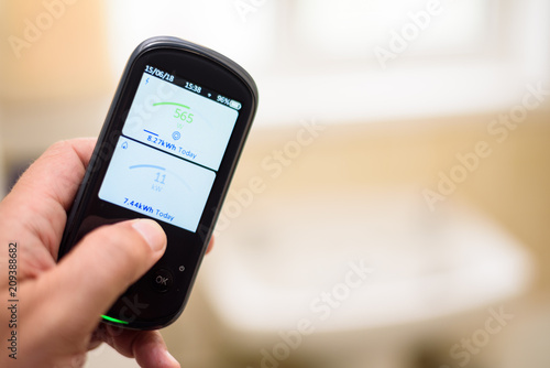 Canvastavla Man holding a Domestic Energy Smart Meter unit in a bathroom, Displaying Energy