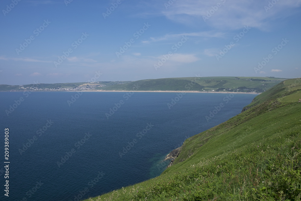view of Puttsborough Sands and Woolacombe beach with the sea beyond and blue sky on a sunny day in the summer. North Devon, United Kingdom