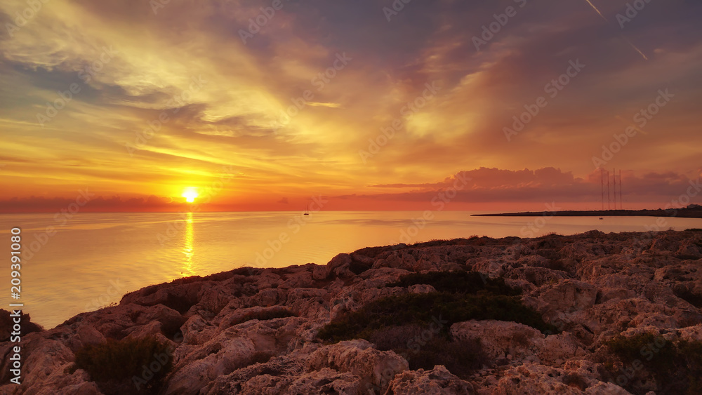Fototapeta Cyprus beautiful sunrise with rocks and cloudy colorful sky, natural sea panoramic background