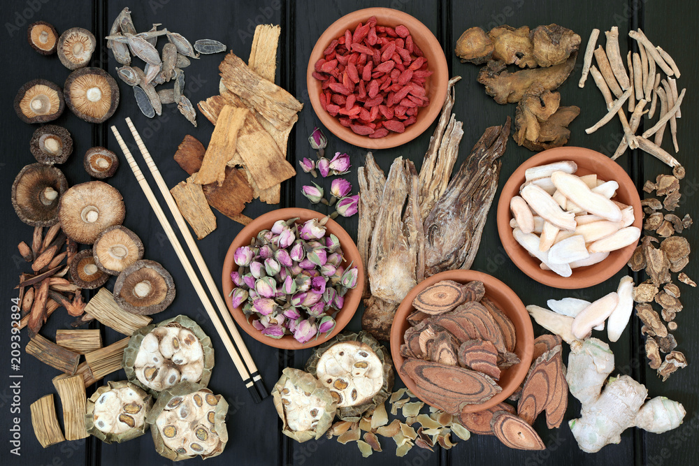 Traditional chinese herbs used in herbal medicine in terracotta bowls and loose on dark wood background. Traditional chinese herbs used in herbal medicine in terracotta bowls and loose on dark wood background.