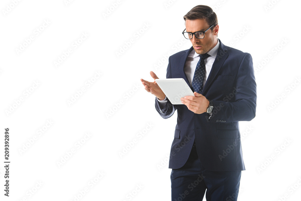 shocked businessman in eyeglasses gesturing by hand and looking at digital tablet screen isolated on white background shocked businessman in eyeglasses gesturing by hand and looking at digital tablet screen isolated on white background