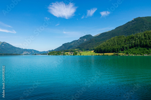 Türkiser See mit Bergen und Wolken am blauen Himmel in Österreich mit dem Namen Wolfgangsee