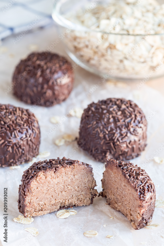 Swedish sweets Arrack balls, made from cookie crumbs, cocoa, butter and coconut wine Arrack flavour, on a wooden table, vertical Swedish sweets Arrack balls, made from cookie crumbs, cocoa, butter and coconut wine Arrack flavour, on a wooden table, vertical