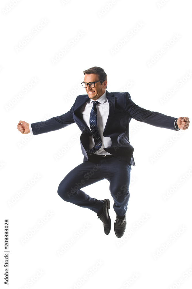excited businessman in eyeglasses jumping and gesturing by hands isolated on white background