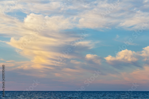 Clouds in the background of the setting sun and the sea