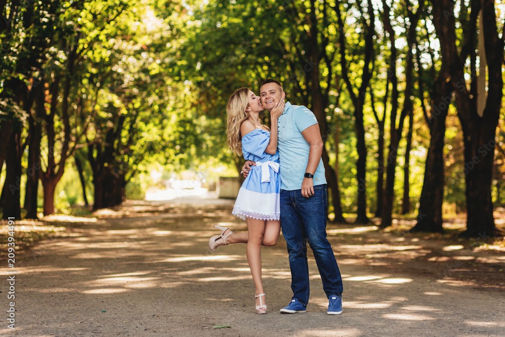 Fototapeta premium couple of lovers on a walk along the park avenue. Summer time