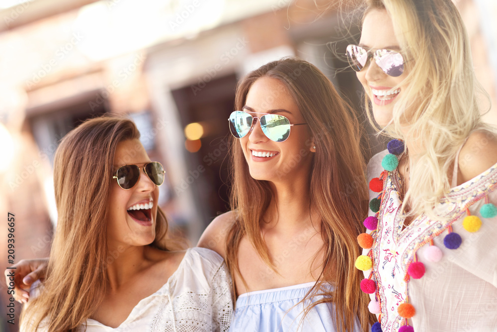 Happy girl friends hanging out in the city in summer Happy girl friends hanging out in the city in summer