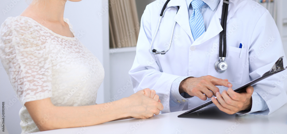 Doctor and patient talking while sitting at the table . Concept of support and trust in medicine Doctor and patient talking while sitting at the table . Concept of support and trust in medicine
