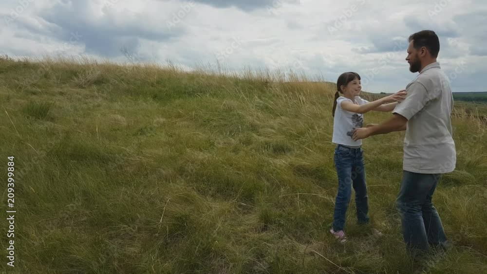 a bearded man with a daughter spinning in nature. my daughter and my father play in nature. a bearded man with a daughter spinning in nature. my daughter and my father play in nature.