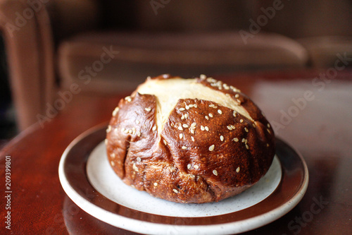 baked pretzel Kaiser bun with sesame seeds